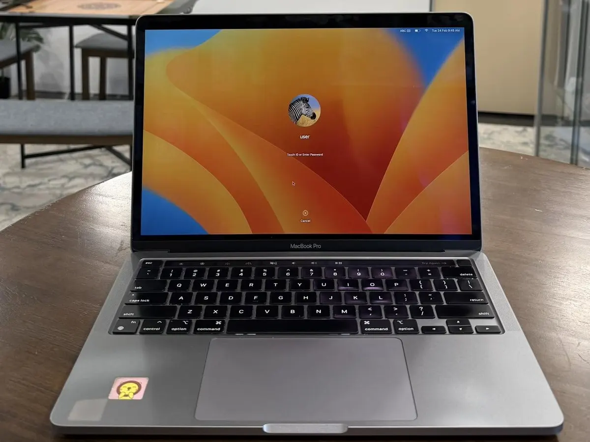 MacBook Pro switched on at its login screen on a wooden table